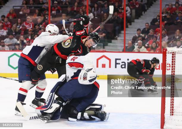 Brady Tkachuk of the Ottawa Senators is pushed into Darcy Kuemper of the Washington Capitals by Nick Jensen in the second period of the game at...