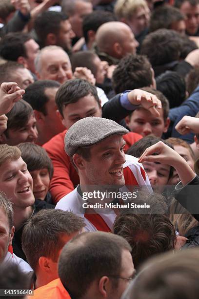 Jos Hooiveld of Southampton sports a flatcap given to him by a home supporter as celebrations begin after Southamptons 4-0 victory and promotion to...