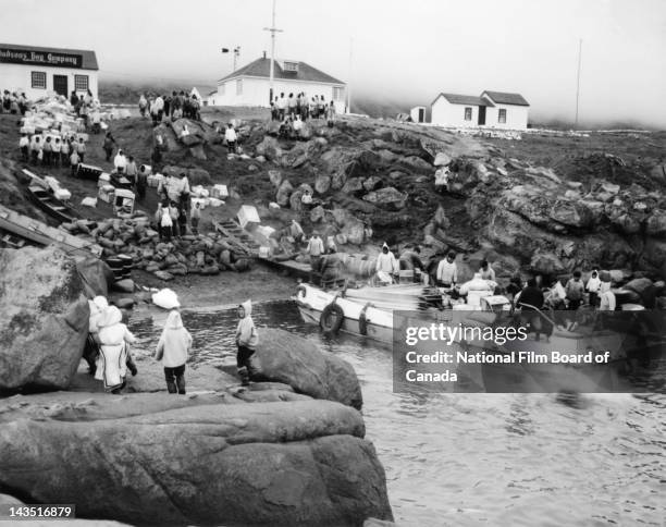 View of the Inuit community of Pangnirtung, with the Hudson's Bay Company trading post seen in the background, gathered on the shore of the village...