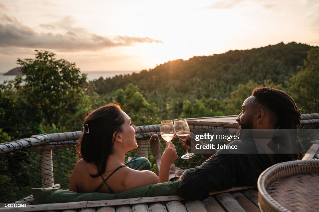 Un couple aime regarder le coucher de soleil avec un verre de vin