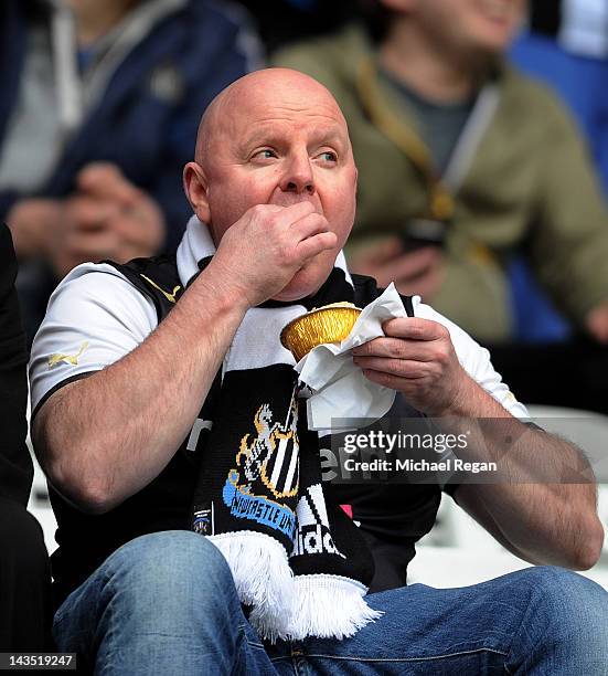 Newcastle fan eats a pie during the Barclays Premier League match between Wigan Athletic and Newcastle United at the DW Stadium on April 28, 2012 in...