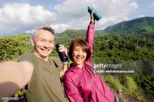 portrait of asian seniors selfie in the mountains after a workout - dramatic millennials stock pictures, royalty-free photos & images