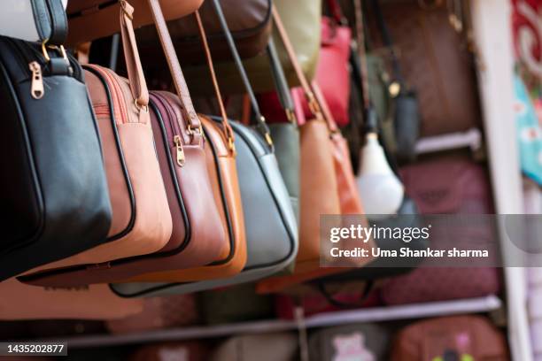 purses hanging at street market. - designerkleding stockfoto's en -beelden