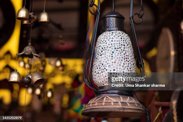 antique lantern hanging outside a store front. - antique lightbulb stockfoto's en -beelden