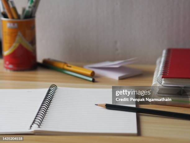 a notebook and pencil pen are placed on a wooden table - workbook stock pictures, royalty-free photos & images