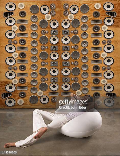 man relaxing in front of wall of speakers - stereo fotografías e imágenes de stock
