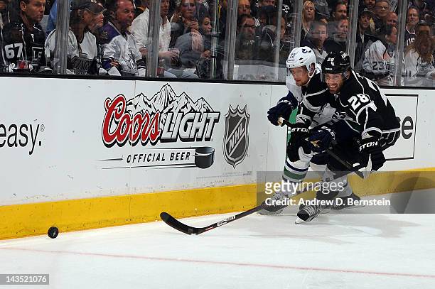 Jarret Stoll of the Los Angeles Kings reaches for the puck against Alexander Edler of the Vancouver Canucks in Game Four of the Western Conference...