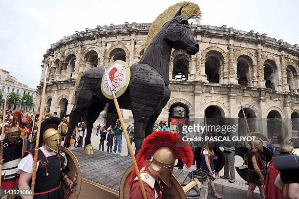 People parade with a Trojan horse during an historical reenactment in front of the amphitheatre as part of the third edition of the Roman Games on...