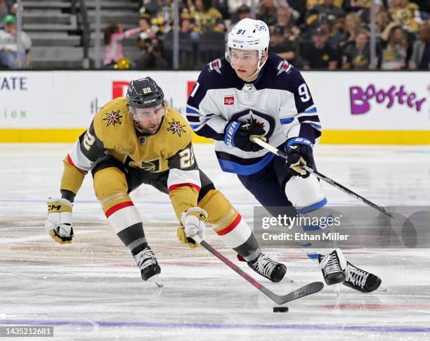 Cole Perfetti of the Winnipeg Jets skates with the puck against Michael Amadio of the Vegas Golden Knights in the third period of their game at...