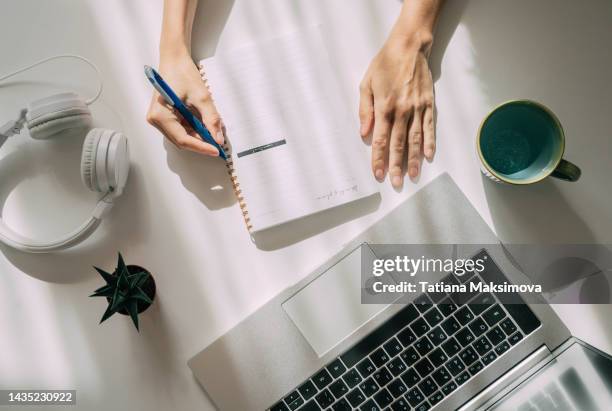 workspace with laptop and humans hands, white background. - office work flat lay stock-fotos und bilder