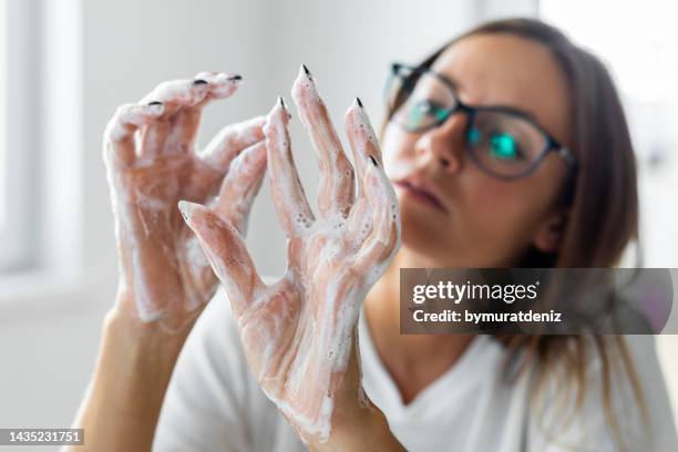 woman obsessively washing her hands - obsessive stockfoto's en -beelden