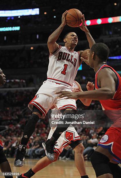 Derrick Rose of the Chicago Bulls grimaces as he goes up to pass over Lavoy Allen of the Philadelphia 76ers after apparently injuring his knee in...