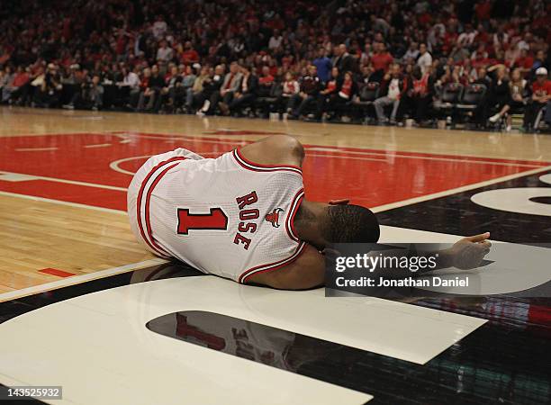 Derrick Rose of the Chicago Bulls lays on the floor aftrer suffering an injury against the Philadelphia 76ers in Game One of the Eastern Conference...