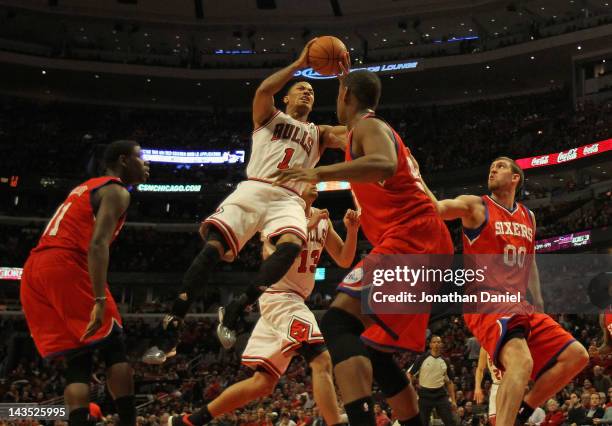 Derrick Rose of the Chicago Bulls grimaces as he goes up to pass over Lavoy Allen of the Philadelphia 76ers after apparently injuring his knee as...