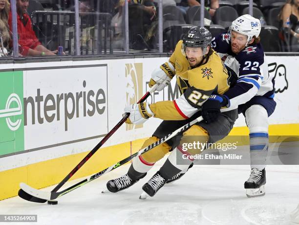 Shea Theodore of the Vegas Golden Knights skates with the puck against Mason Appleton of the Winnipeg Jets in the third period of their game at...