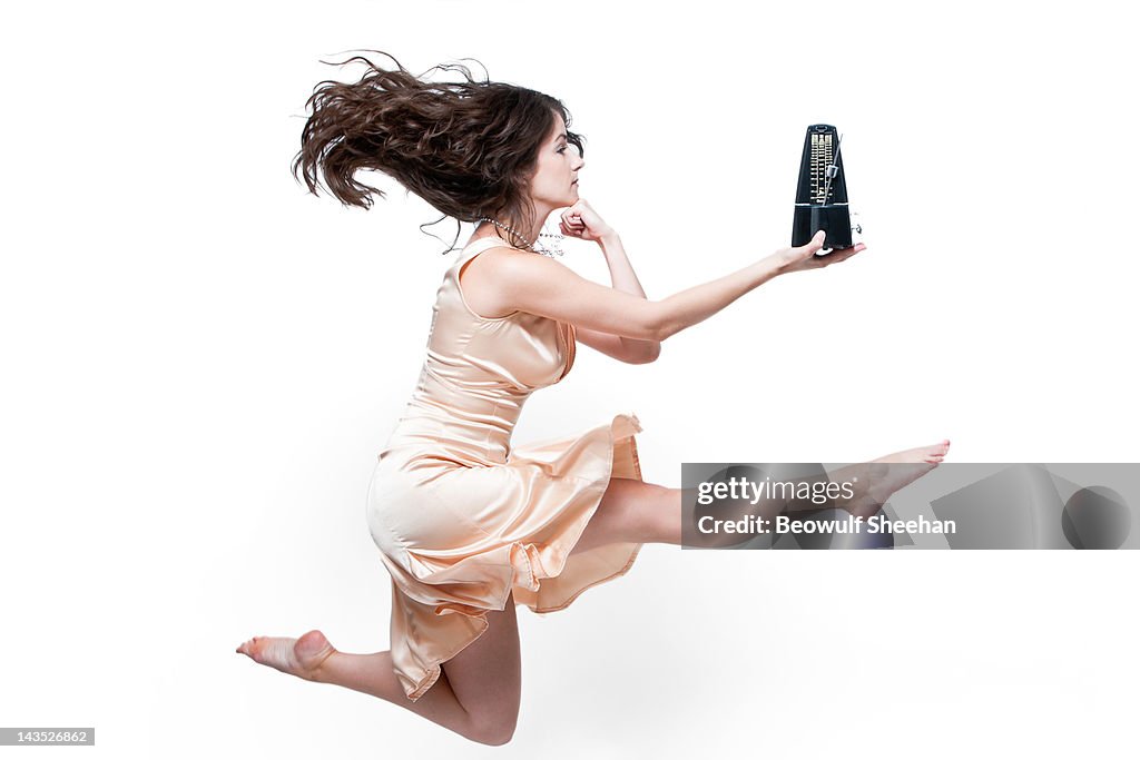 Woman dancer in pearls and dress with metronome