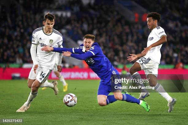 Harvey Barnes of Leicester City is tackled by Tyler Adams and Diego Llorente of Leeds United during the Premier League match between Leicester City...