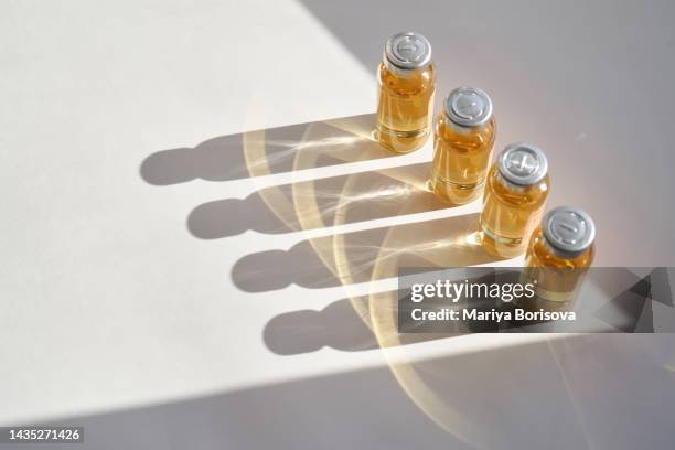 vials of medicines in sunlight on a light background. - ampoule stock-fotos und bilder