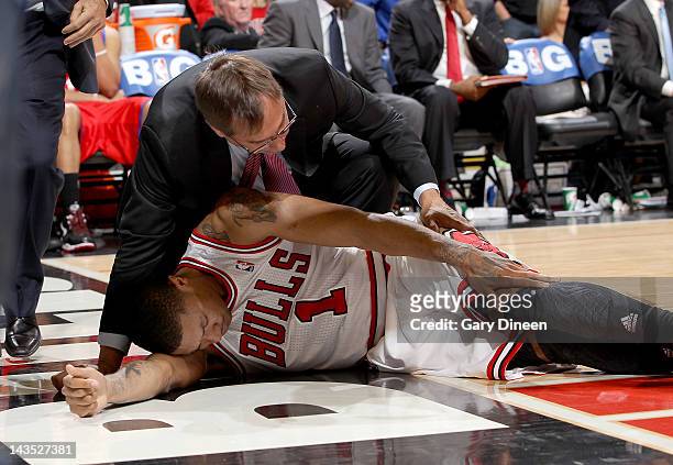 Chicago Bulls Head Athletic Trainer Fred Tedeschi assists Derrick Rose after injuring his knee against the Philadelphia 76ers in Game One of the...