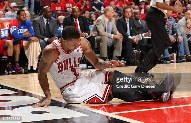 Derrick Rose of the Chicago Bulls sits on the floor after injuring his knee against the Philadelphia 76ers in Game One of the Eastern Conference...
