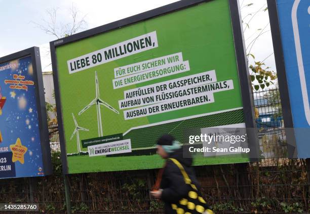 Young woman walks past a billboard paid for by the German government that seeks to reassure citizens over the country's energy situation on October...