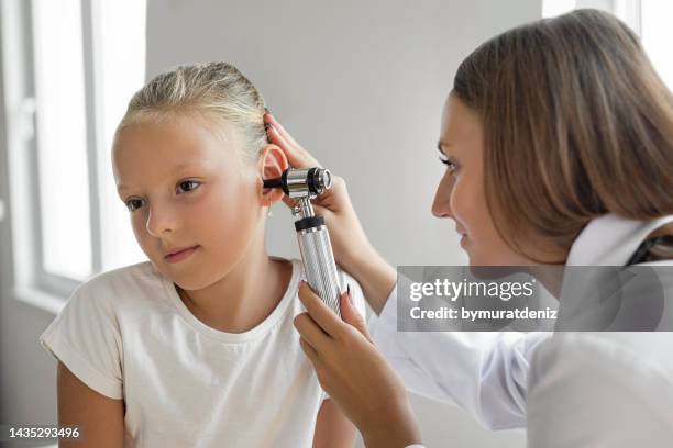 girl patient is getting an ear examination - ear exam stock pictures, royalty-free photos & images