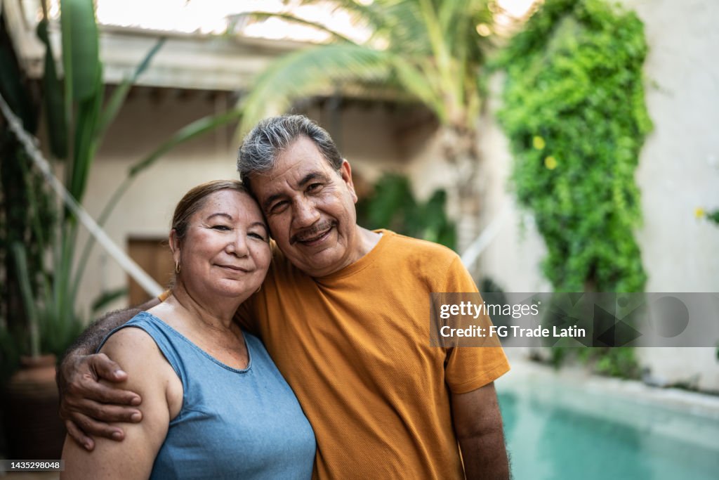 Portrait of mature couple embracing by the pool