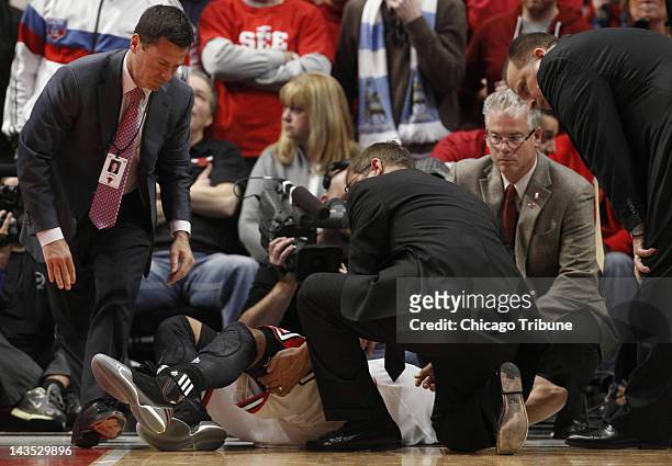 The Chicago Bulls' Derrick Rose is helped by head athletic trainer Fred Tedeschi after he was injured late in the game against the Philadelphia 76ers...