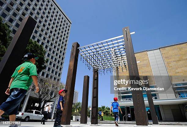 Children walk under an art installation outside the new LAPD Metroplolitan Detention Center built at the site where a parking kiosk was burned in...