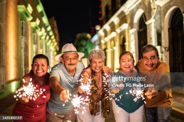 retrato de amigos seniores celebrando o ano novo com luzes de bengala no distrito histórico - bengal new year - fotografias e filmes do acervo