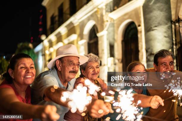 amigos seniores celebrando o ano novo com luzes de bengala no distrito histórico - bengal new year - fotografias e filmes do acervo