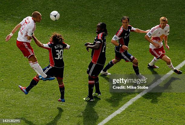 Brandon Barklage of the New York Red Bulls heads the ball as Greg Jordan and Krystian Witkowski of the New England Revolution and team-mate Markus...