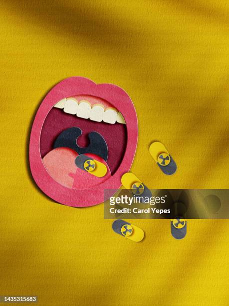 mouth taking some anti radiation pills of iodine.paper craft - radiation symbol stock pictures, royalty-free photos & images
