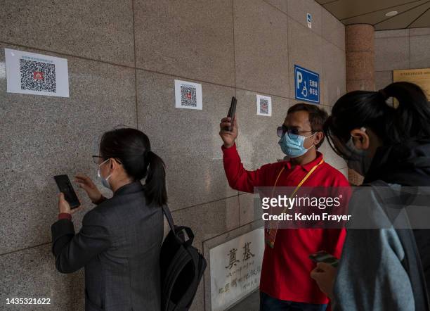 People scan their health codes for COVID-19 at the entrance to a closed loop medial hotel for journalists and officials attending the 20th National...