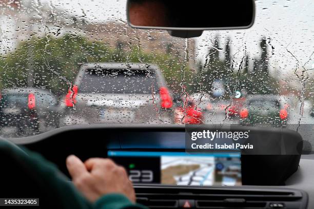 view from car with rain drops of traffic jam in the street - lluvia torrencial fotografías e imágenes de stock