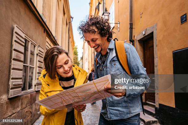 young tourist couple reading a map in the city in stockholm - description stock pictures, royalty-free photos & images