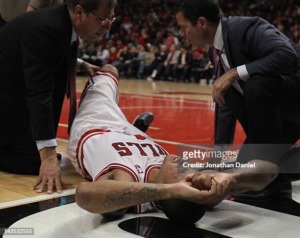 Derrick Rose of the Chicago Bulls is examined after suffering an injury against the Philadelphia 76ers in Game One of the Eastern Conference...