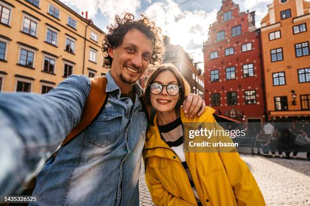 young couple taking a selfie in stockholm - zelfportret stockfoto's en -beelden