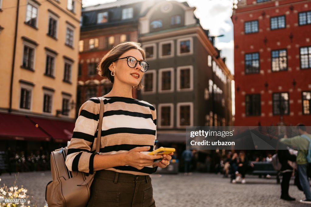 Young Woman Using Phone On The Street In Stockholm