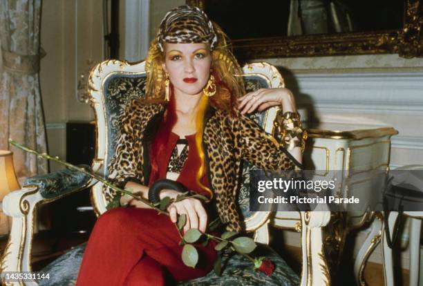 American singer and songwriter Cyndi Lauper, wearing a leopard print outfit during the presentation of a gold disc for her 1983 debut album, 'She's...