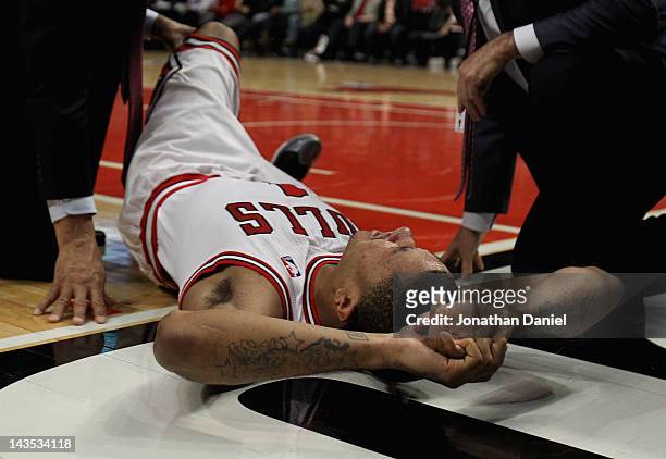 Derrick Rose of the Chicago Bulls is examined after suffering an injury against the Philadelphia 76ers in Game One of the Eastern Conference...