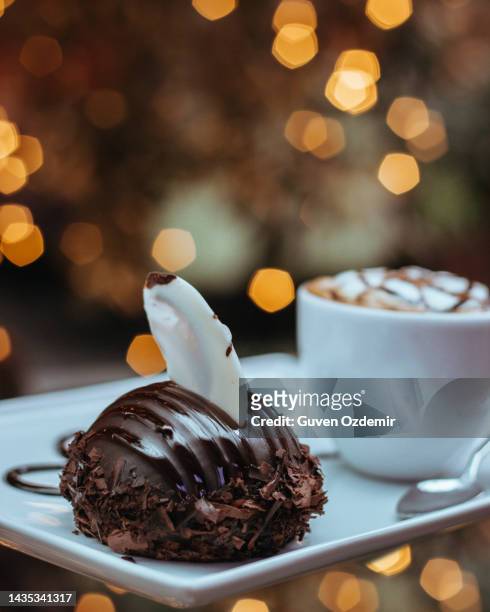 mini chocolate cake and art coffee served to the table - drink dark background stockfoto's en -beelden