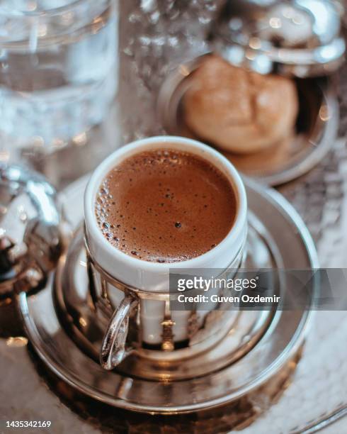 伝統的なトルコのコーヒーカップとクッキーのサービス、トルココーヒーとクッキーの伝統的なエンボス加工された金属トレイとカップ、伝統的なコーヒーのコンセプト - ジェズベ ストックフォトと画像