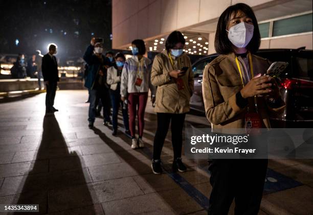 People line-up for their second nucleic acid test of the day to detect COVID-19, required for journalists, staff, and officials staying at a closed...