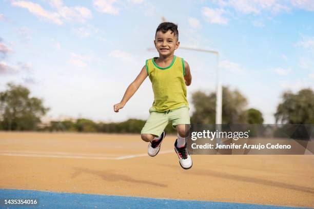 closeup of healthy boy 5-6 years old on yellow basketball court jumping happily. - old trying to look young stock pictures, royalty-free photos & images