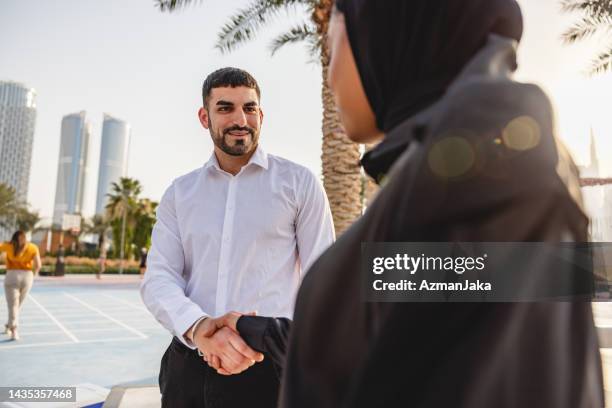 a young middle eastern  business professional shaking hands outdoors in dubai - eastern europe bildbanksfoton och bilder