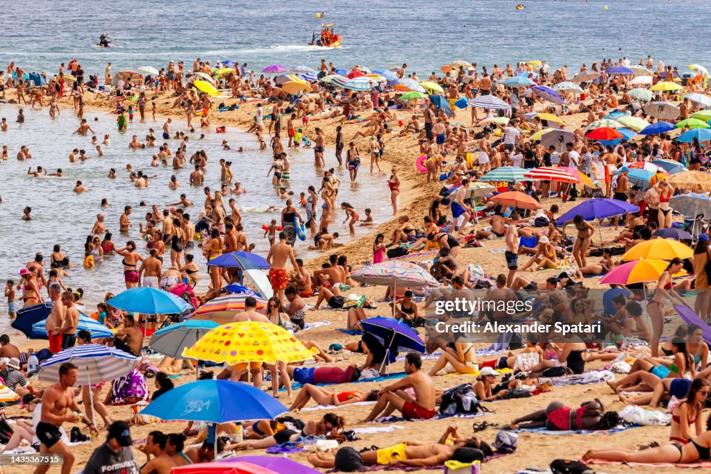 Crowds of tourist on Barceloneta beach, Barcelona, Spain