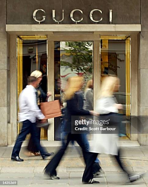 Pedestrians walk past a Gucci store September 27, 2002 in London, England. Italian fashion store Gucci Group warned September 26, 2002 that it may...