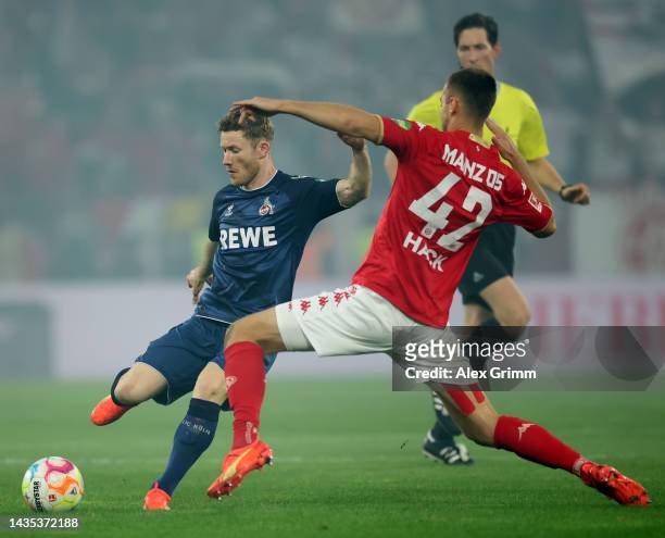 Florian Kainz of 1. FC Koeln shoots under pressure from Alexander Hack of 1. FSV Mainz 05 during the Bundesliga match between 1. FSV Mainz 05 and 1....