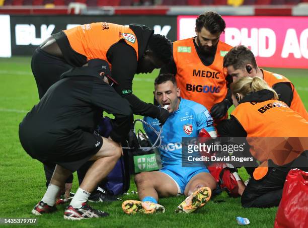 Jonny May of Gloucester reeives attention after injuring his left arm during the Gallagher Premiership Rugby match between London Irish and...